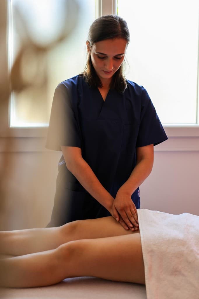 Imane Abarar réalisant un soin de drainage lymphatique à la lumière naturelle du cabinet.